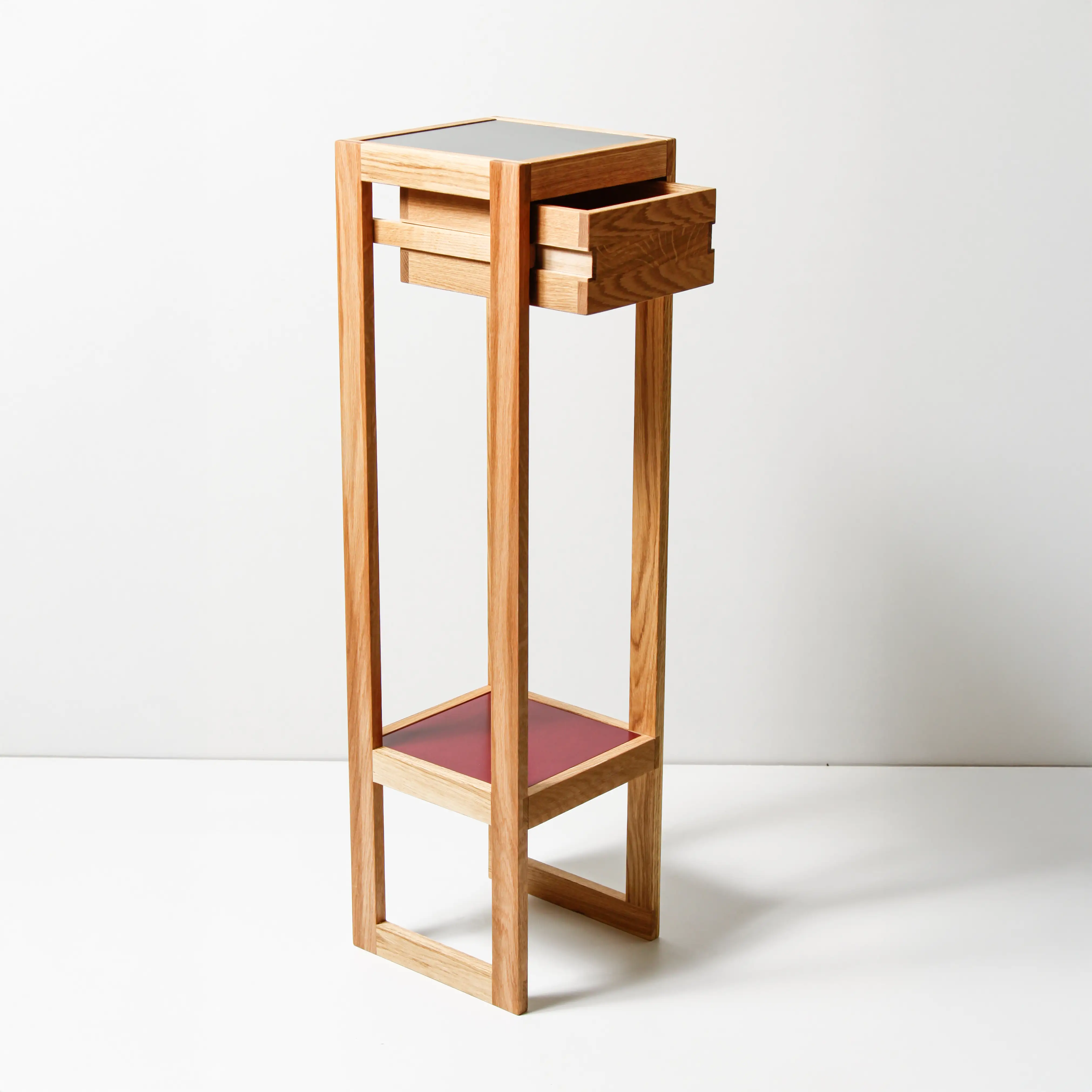 Hohes, minimalistisches Beistelltischmöbel aus Eichenholz mit einer offenen Schublade und einer Ablagefläche unten.