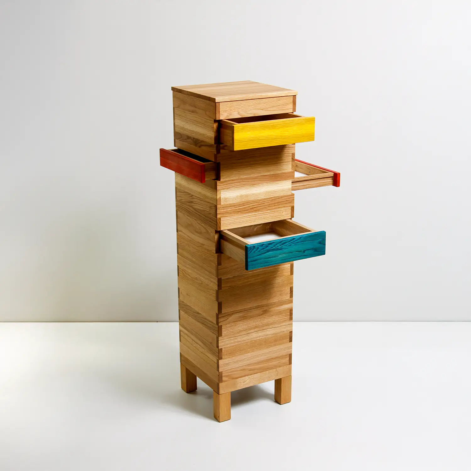 Schmale Holzsäule mit bunten Schubladen.